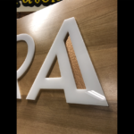White dimensional lettering on wood signage