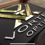 Custom business signage for Vortex Optics in gold, black, and white