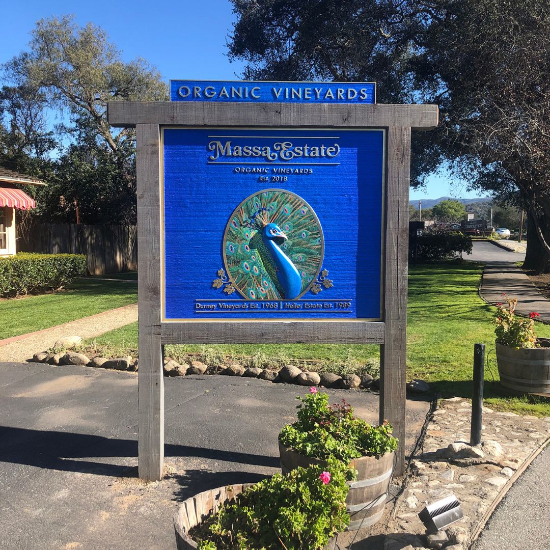 3D Sign reading "Massa Estate" with a peacock