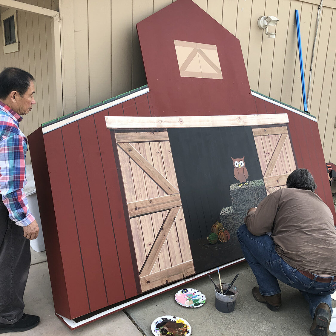 Painting a custom agriculture field sign of a barn for one of our clients